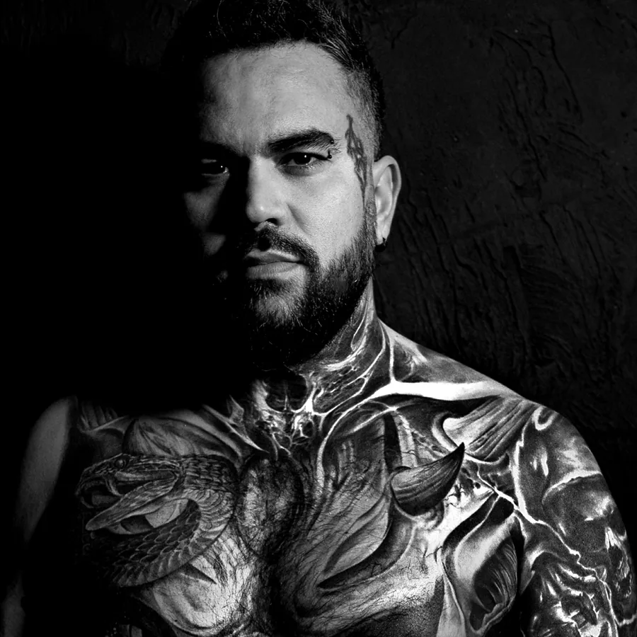 Adem, Japanese specialist, photographed against black in the studio; chest and shoulders covered in his own large-scale black and grey work.