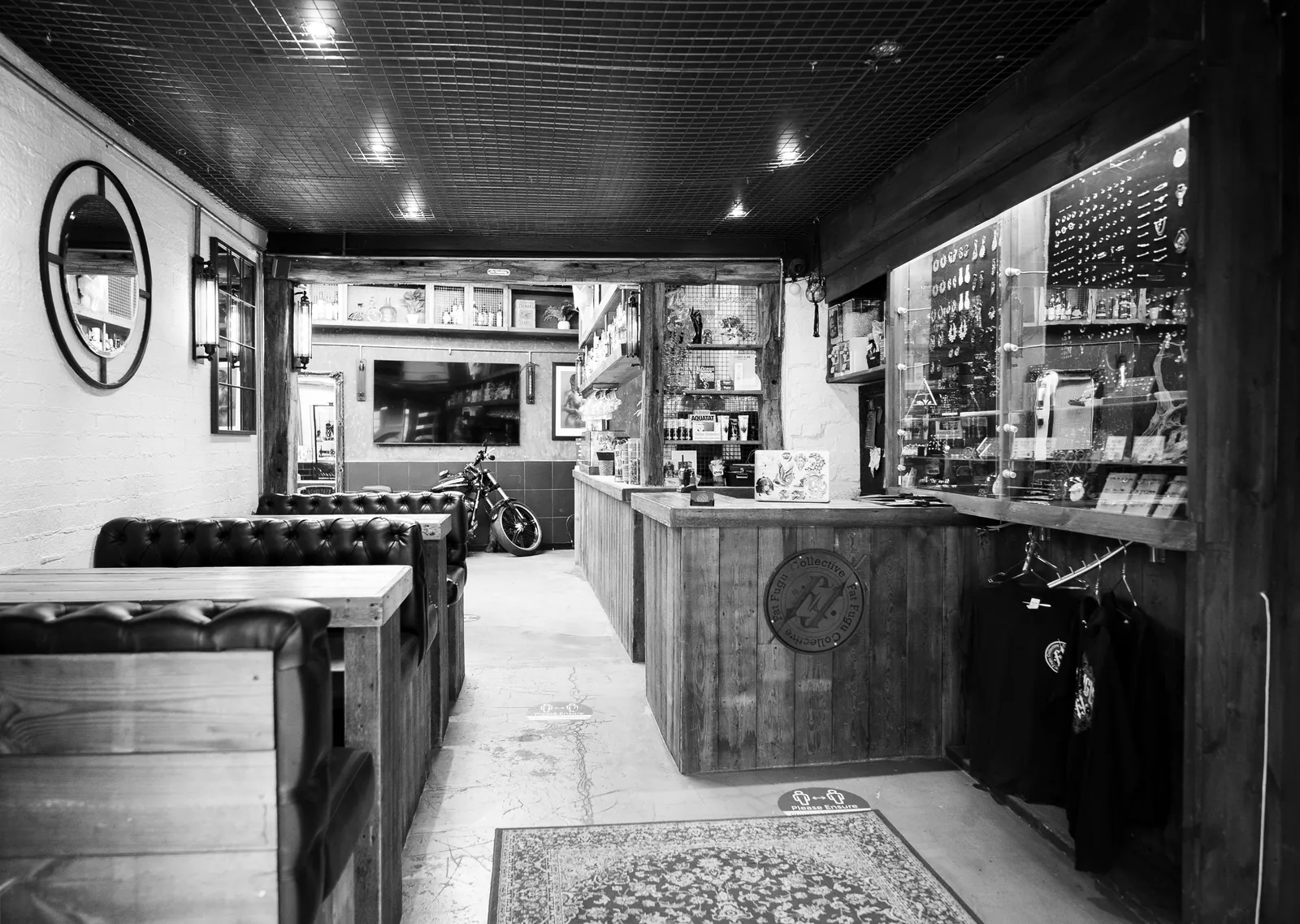The Fat Fugu reception looking down the room: leather booth seating on the left, jewellery cabinets and the counter on the right, rug on a poured concrete floor.