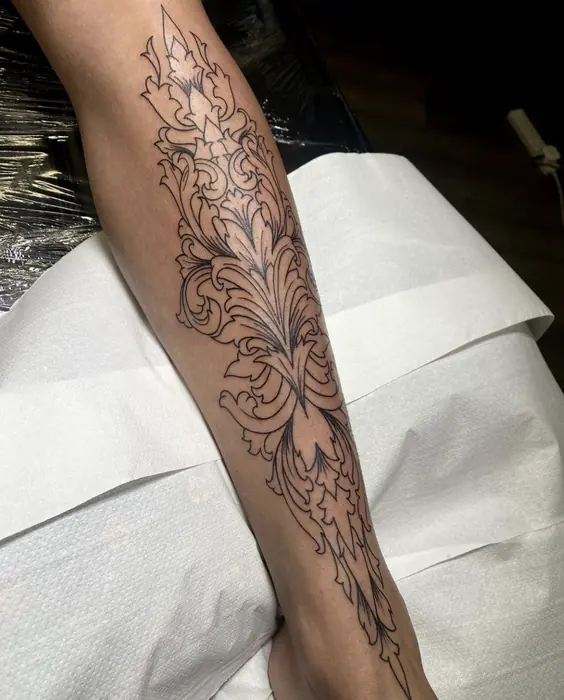 A blackwork ornamental forearm piece, foliage and filigree worked in fine line and stipple.