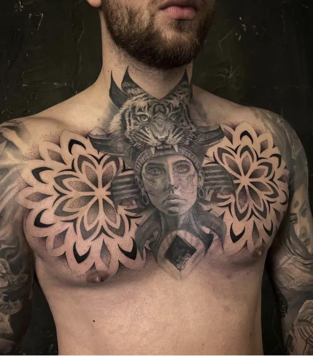 A blackwork chest piece: two large dotwork mandalas either side of a central ornamental face.