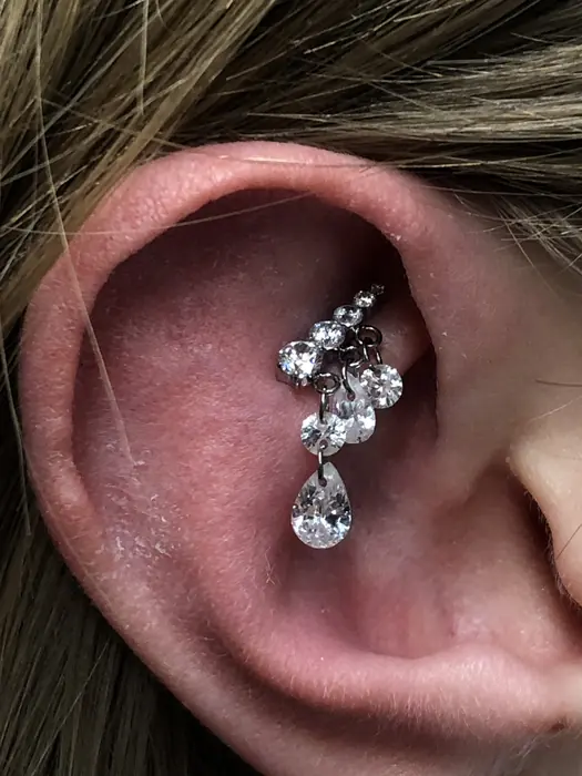 A rook piercing with a clustered gem drop, healed and seated.