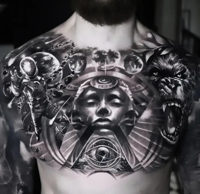 A black and grey realism chest piece built around a central face and an all-seeing eye, flanked by a snarling wolf and an armoured figure.