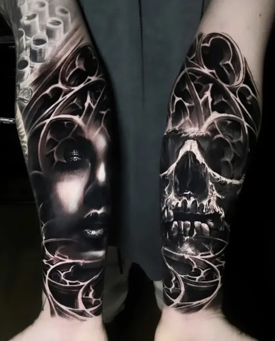 A matching pair of black and grey forearm pieces, a portrait on one arm and a skull on the other, shot together.
